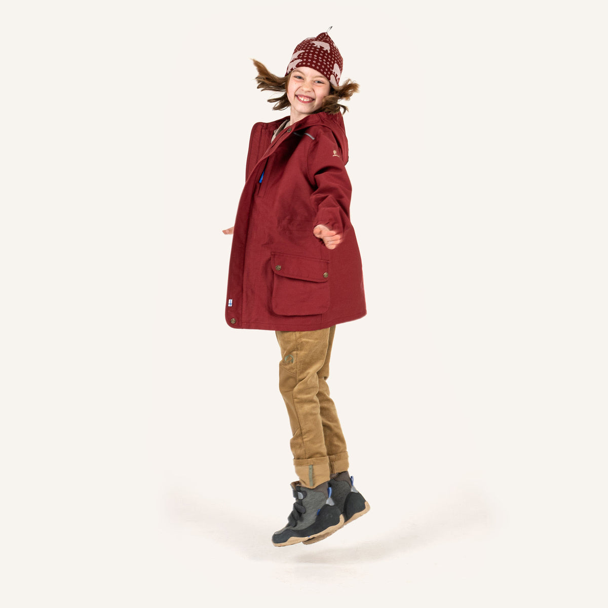 KUULU Kinderoutfit: weinrote Jacke, beigefarbene Hose, gestrickte Mütze