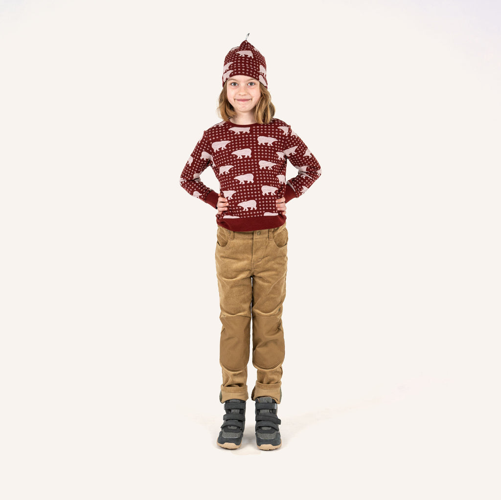 KUULU Kinderoutfit: weinrotes Tiermuster-Oberteil, beigefarbene Hose, rote Mütze
