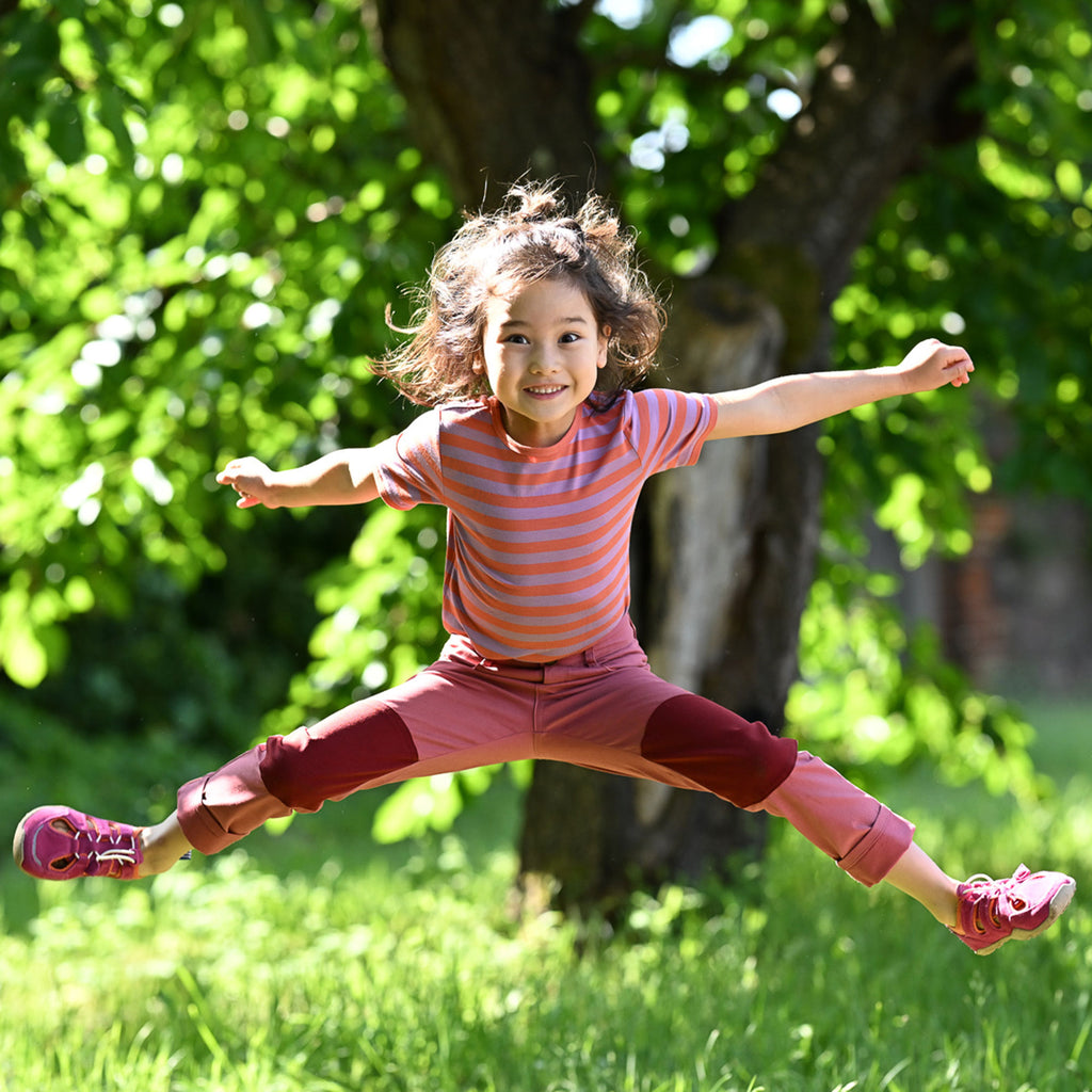 Child wearing an orange-pink striped t-shirt with a crew neck and short sleeves
