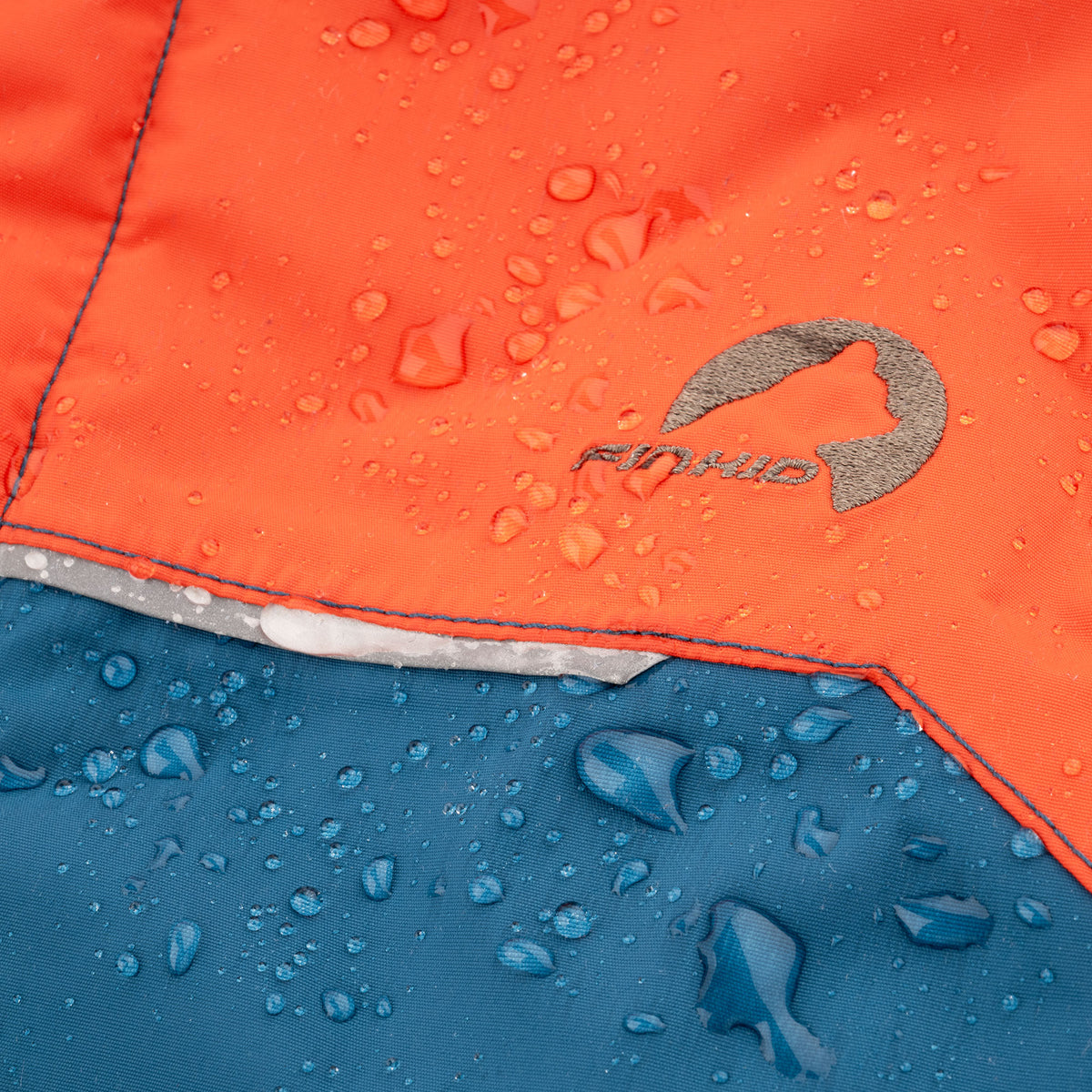Water-repellent orange jacket fabric with logo, visible droplets