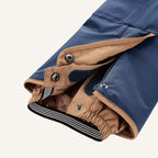 Snow pants detail: dark blue fabric with beige inner lining, snaps and zipper at the cuff