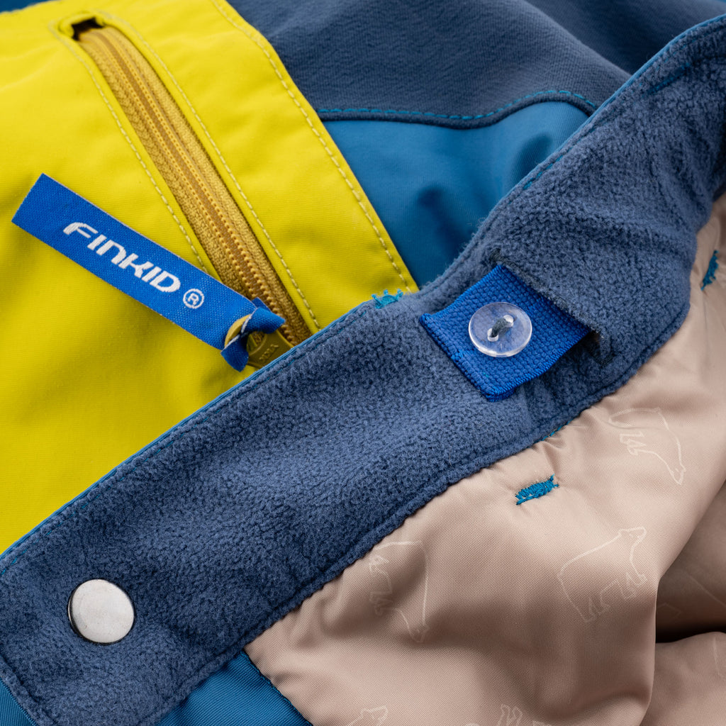 Snow pants with a yellow-blue front panel, fleece cuffs, and snap button